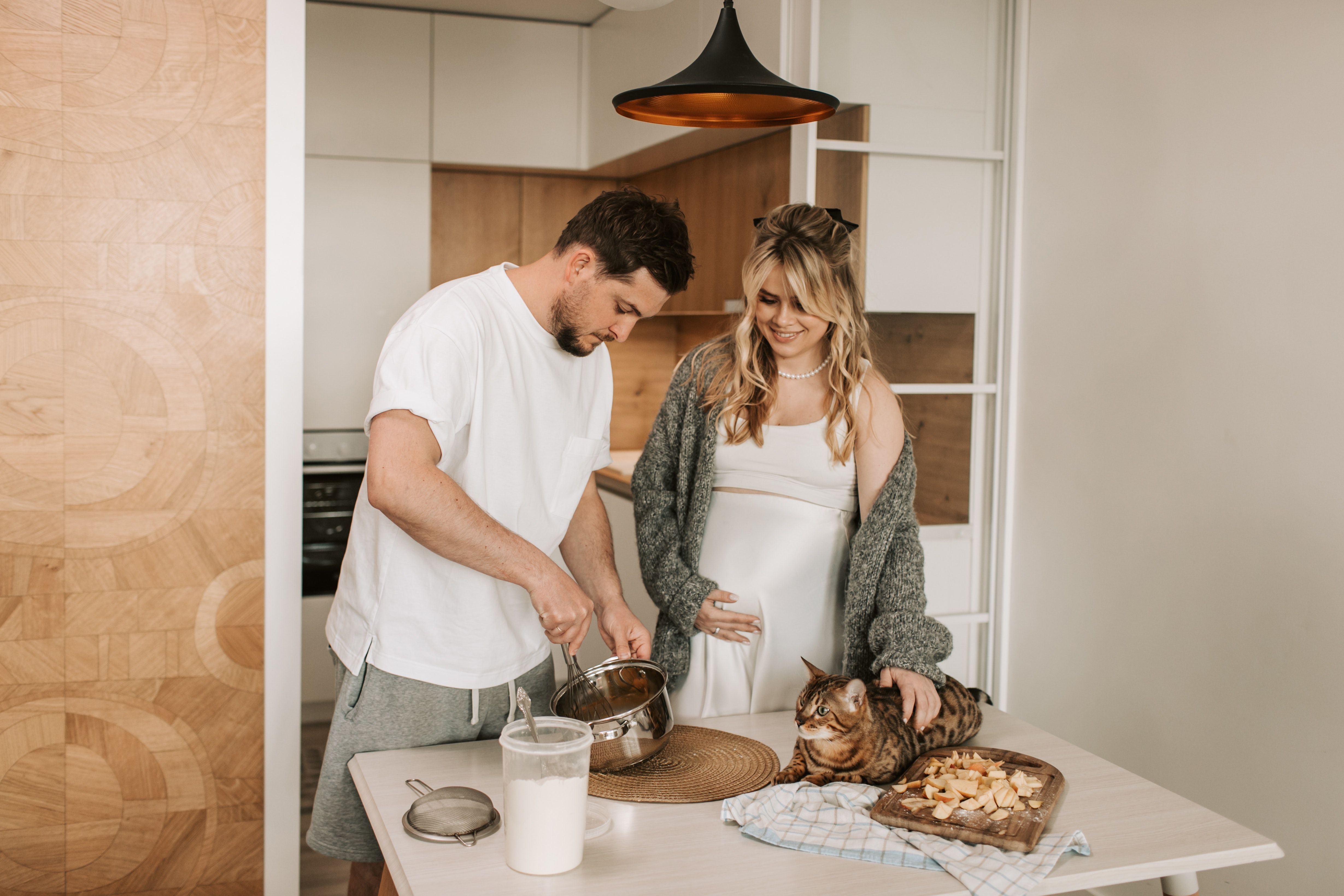 Pregnant woman and husband making dinner